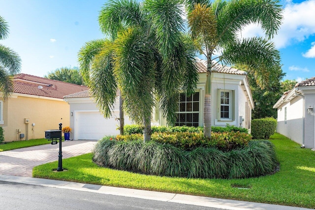 mediterranean / spanish-style home featuring a front yard and a garage