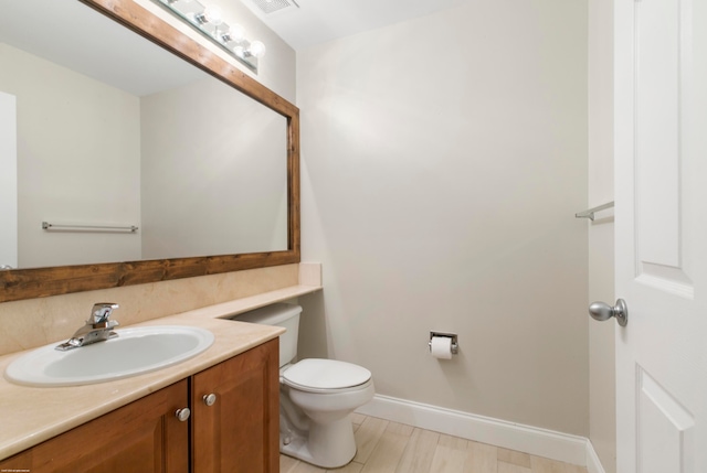 bathroom with wood-type flooring, vanity, and toilet