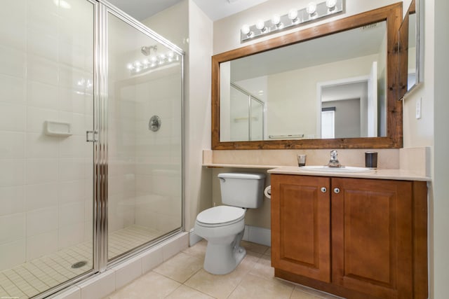 bathroom featuring vanity, toilet, a shower with door, and tile patterned floors