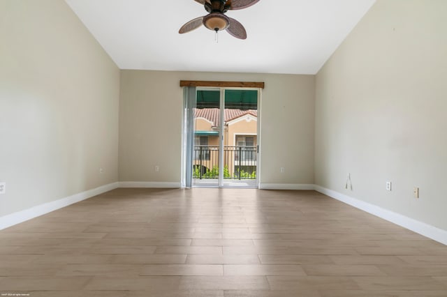 spare room featuring light hardwood / wood-style flooring, vaulted ceiling, and ceiling fan