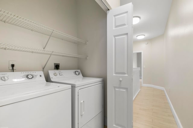 laundry room featuring washing machine and clothes dryer and light wood-type flooring