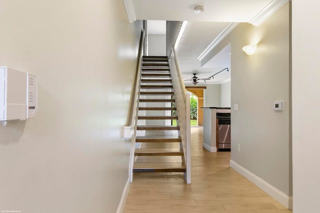 stairs featuring crown molding, hardwood / wood-style floors, and ceiling fan