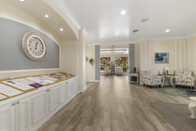 corridor featuring light hardwood / wood-style flooring and crown molding