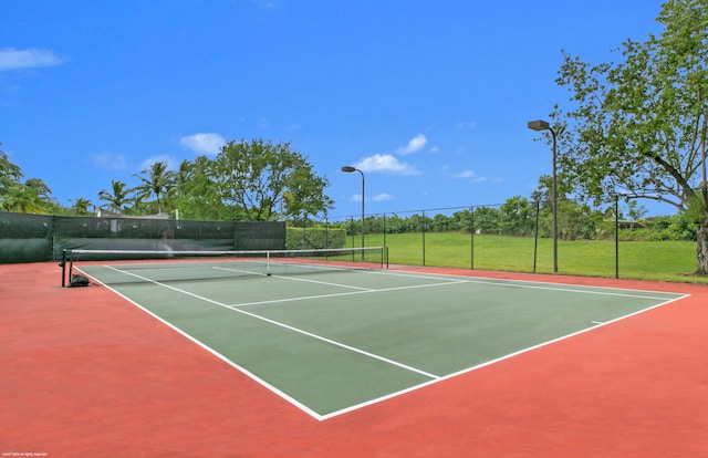 view of sport court with basketball hoop and a lawn