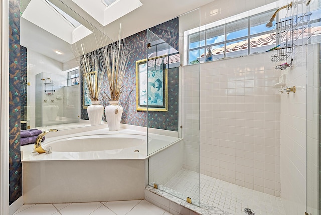 bathroom featuring a skylight, independent shower and bath, and tile patterned flooring