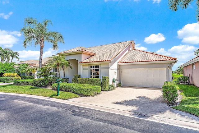 mediterranean / spanish-style house featuring a garage and a front lawn