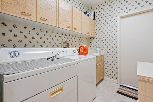 clothes washing area with cabinets, independent washer and dryer, and light tile patterned flooring