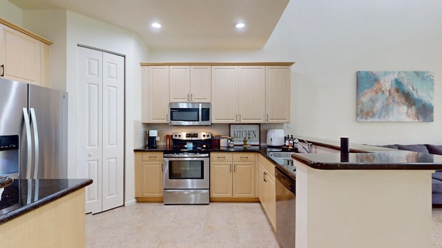 kitchen featuring stainless steel appliances, sink, light brown cabinets, kitchen peninsula, and light tile patterned flooring