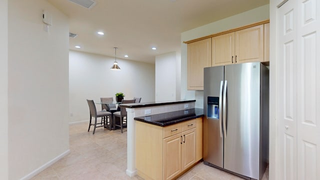 kitchen with light brown cabinetry, decorative light fixtures, kitchen peninsula, and stainless steel refrigerator with ice dispenser