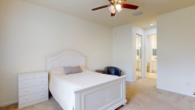 bedroom featuring ceiling fan, light colored carpet, and ensuite bathroom