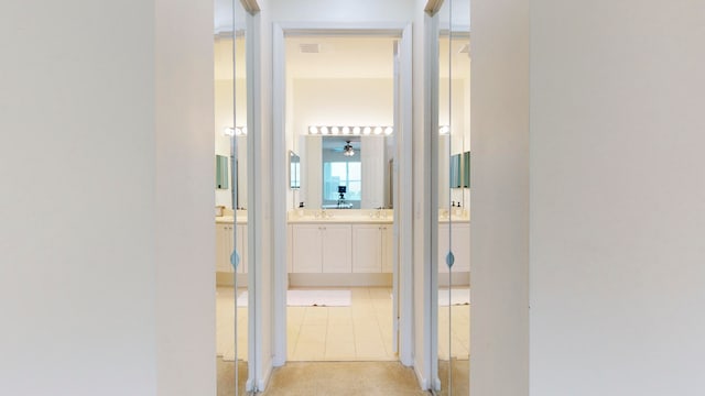 corridor with light tile patterned floors and sink