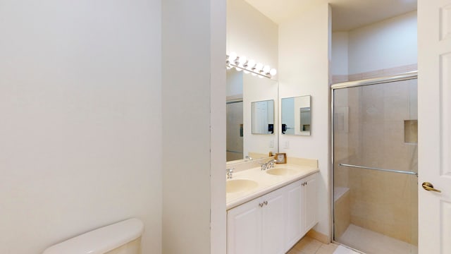 bathroom featuring vanity, toilet, walk in shower, and tile patterned flooring