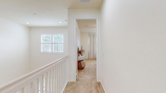 hallway featuring light colored carpet