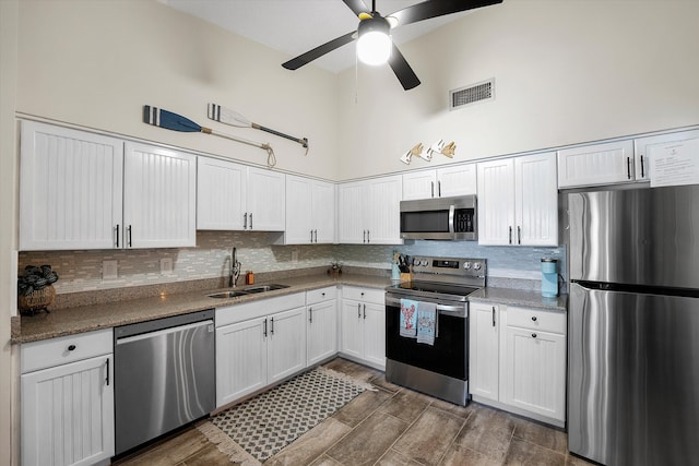 kitchen with ceiling fan, white cabinets, stainless steel appliances, and sink