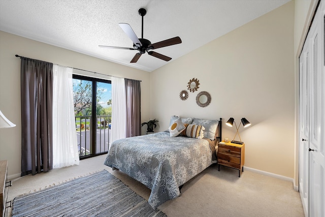 carpeted bedroom featuring access to exterior, a textured ceiling, a closet, lofted ceiling, and ceiling fan