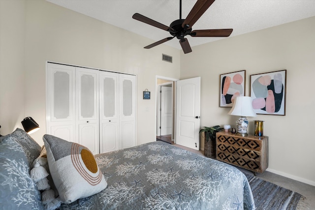 carpeted bedroom with ceiling fan, a textured ceiling, and a closet