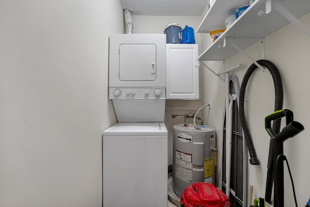 laundry room featuring cabinets, stacked washer / dryer, water heater, and a textured ceiling