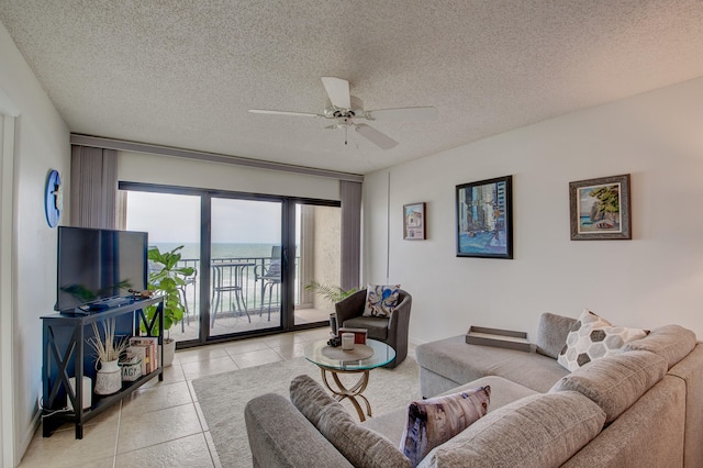 tiled living room with ceiling fan and a textured ceiling