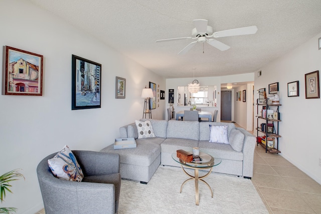 tiled living room with ceiling fan and a textured ceiling