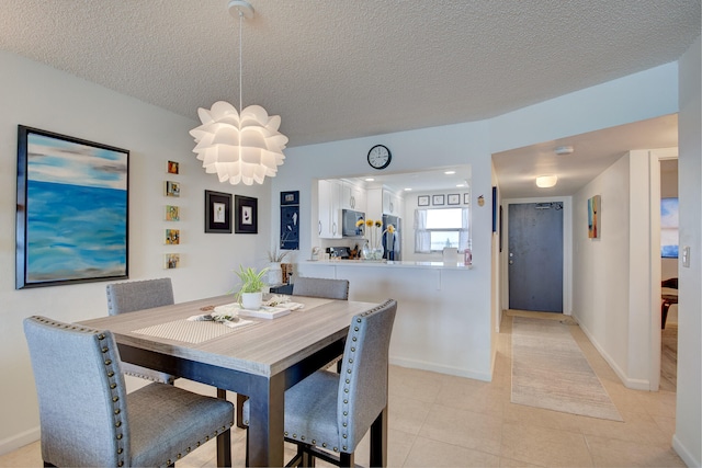 tiled dining room featuring a notable chandelier and a textured ceiling