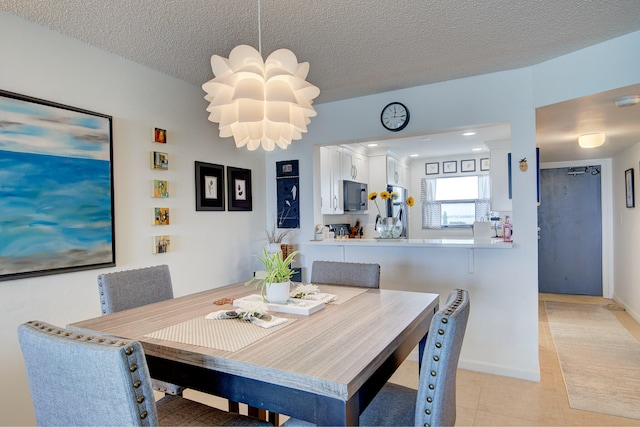 dining area featuring a textured ceiling, an inviting chandelier, and light tile patterned floors