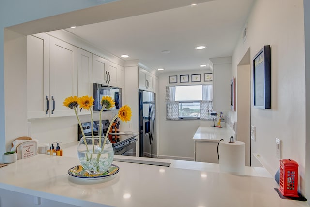 kitchen with kitchen peninsula, tasteful backsplash, stainless steel appliances, and white cabinets