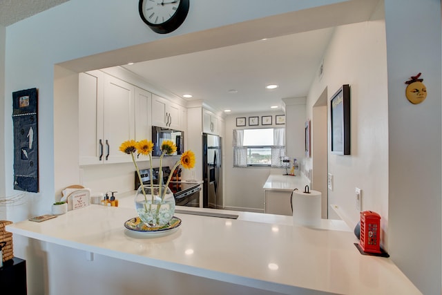 kitchen featuring stainless steel appliances, white cabinets, and kitchen peninsula