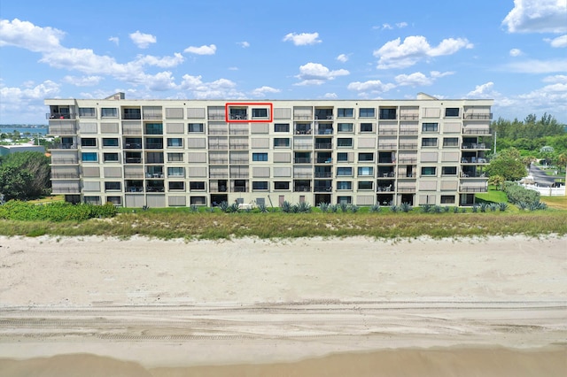 view of property with a water view and a view of the beach