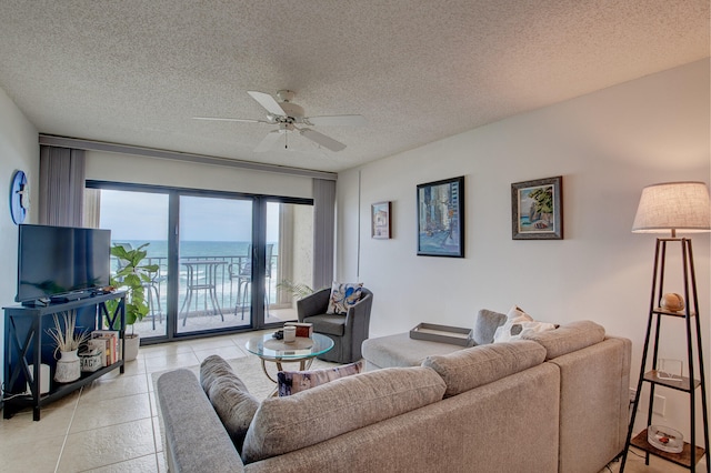 tiled living room featuring ceiling fan and a textured ceiling