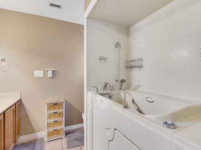 bathroom with a washtub, tile patterned flooring, vanity, and toilet