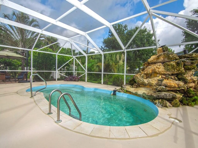 view of pool featuring glass enclosure and a patio area