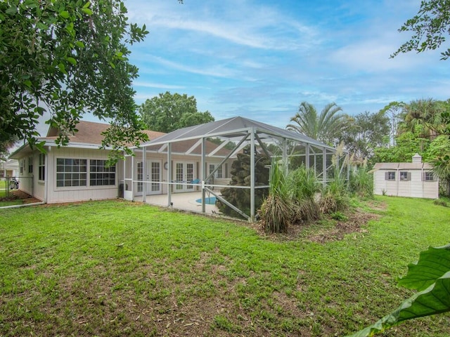 back of house featuring a lanai, a storage shed, and a lawn