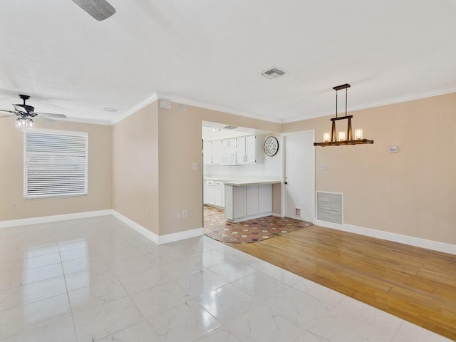 unfurnished living room with ceiling fan with notable chandelier, crown molding, and light hardwood / wood-style flooring