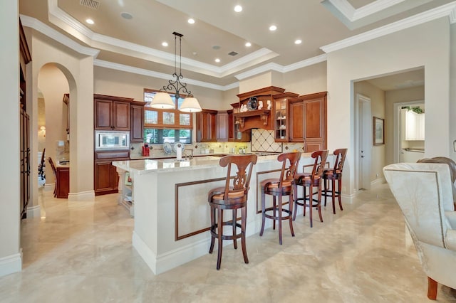 kitchen with appliances with stainless steel finishes, tasteful backsplash, light stone countertops, pendant lighting, and crown molding