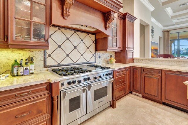 kitchen with light stone counters, backsplash, double oven range, premium range hood, and ornamental molding