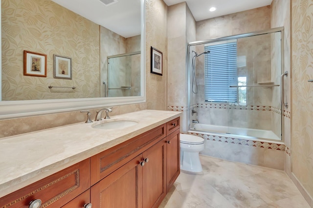 full bathroom featuring enclosed tub / shower combo, vanity, and toilet