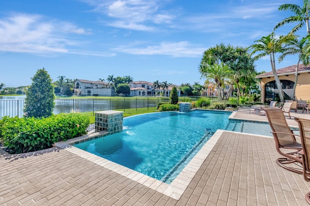 view of pool featuring pool water feature, a patio, and a water view