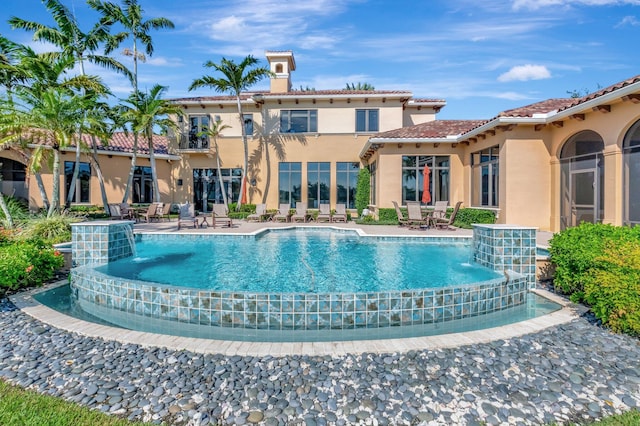 view of swimming pool featuring pool water feature and a patio area