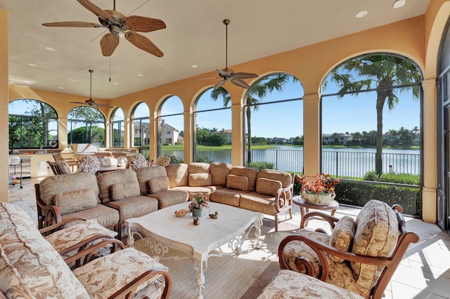 tiled living room with a healthy amount of sunlight, a water view, and ceiling fan