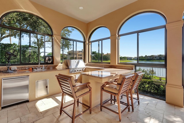 sunroom / solarium with sink and a water view