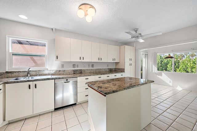 kitchen featuring stainless steel dishwasher, ceiling fan, a center island, and white cabinets