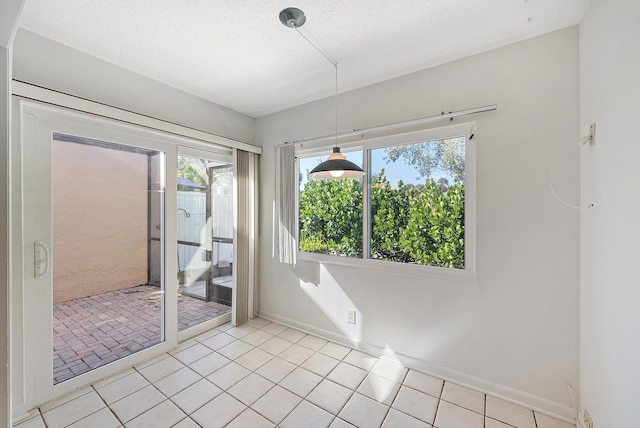 unfurnished room featuring a textured ceiling and light tile patterned floors