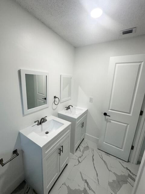 bathroom with a textured ceiling and vanity