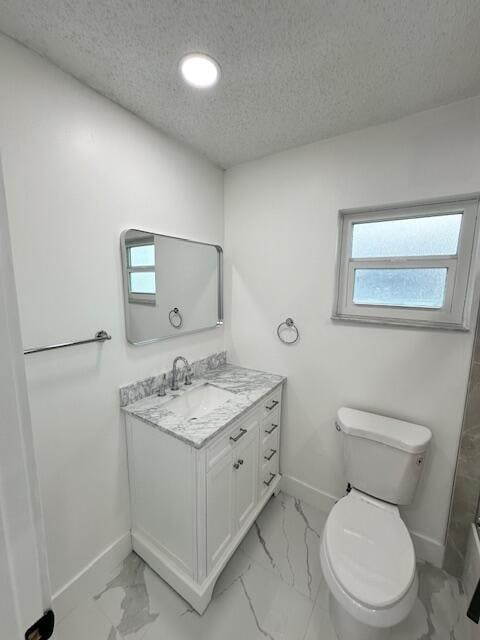 bathroom featuring vanity, toilet, and a textured ceiling