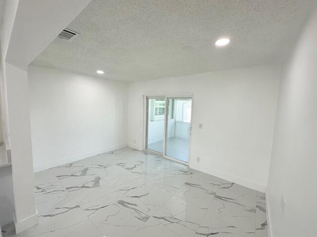 spare room with a textured ceiling