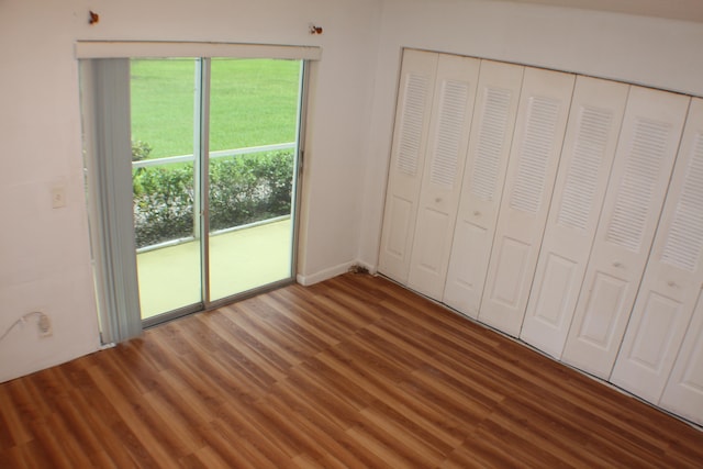 unfurnished bedroom featuring dark wood-type flooring and a closet