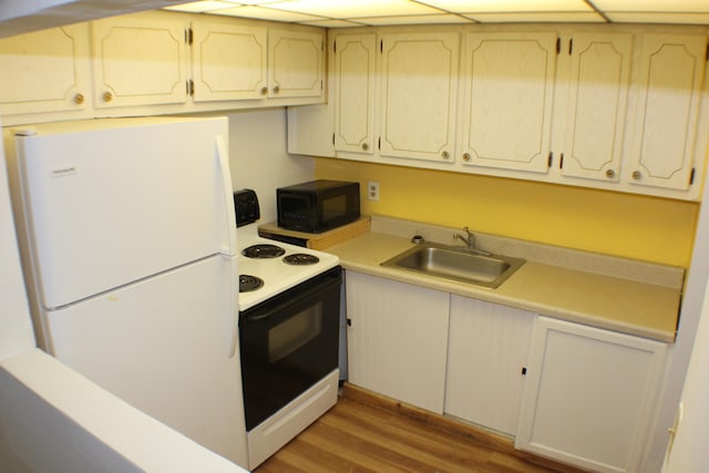 kitchen with light wood-type flooring, white appliances, and sink