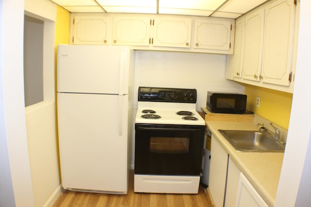 kitchen with sink, white appliances, white cabinetry, and light hardwood / wood-style floors