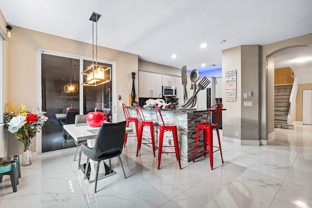 dining area with stairs, arched walkways, recessed lighting, and marble finish floor
