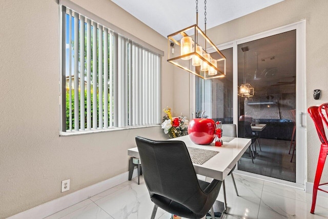 dining space with baseboards, an inviting chandelier, and marble finish floor